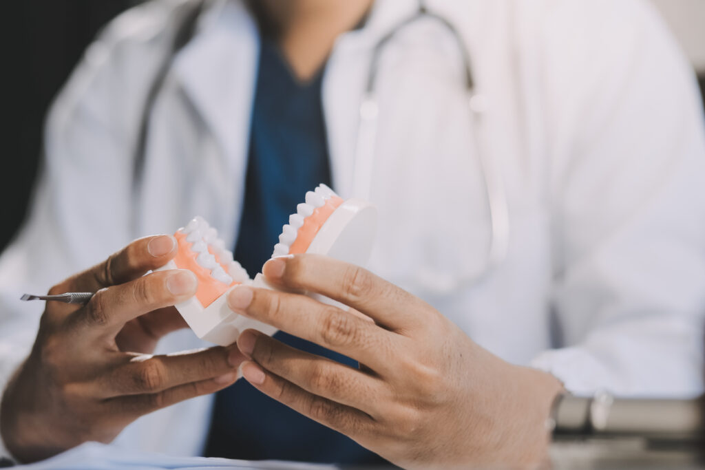 A dentist is using specialized dental equipment to inspect dentures to study the anatomy of the teeth before using the knowledge to treat patients, Dentures are being studied by oral specialists.